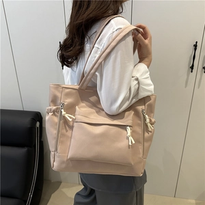 Large apricot nylon tote bag with functional multi-zipper pockets and knot detail