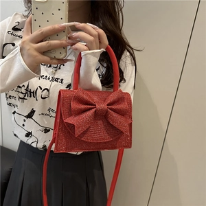 Elegant sparkling red glitter evening handbag with large bow and chain strap
