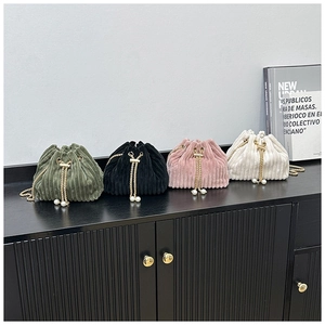 Detail of corduroy drawstring bucket bags in four colors with pearl chain accents