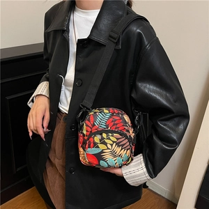 Waterproof crossbody bag with colorful tropical leaf prints worn by female model