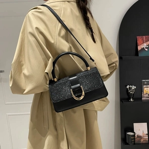Elegante schwarze Umhängetasche mit goldener Hufeisenschnalle aus einem 45-Grad-Winkel