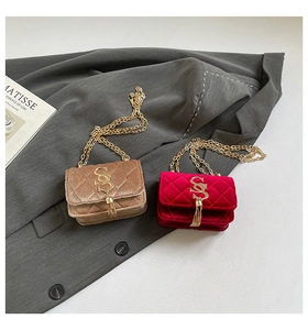 Détail de mini sacs en velours matelassé marron et rouge avec chaînes à pompons dorés