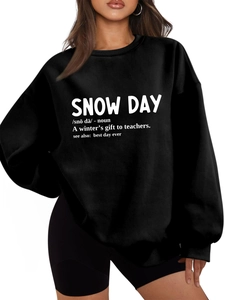 Detailed close-up of the artistic SNOW DAY dictionary print on black plush sweatshirt