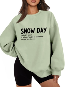 Detail of dictionary-style Snow Day print on green oversized fleece sweatshirt