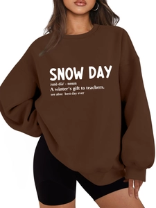 Close-up of dictionary-style snow day print on oversized brown plush sweatshirt