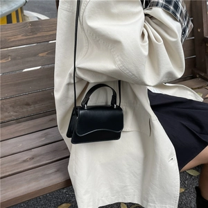 Chic black mini square bag in shiny leather with top handle and crossbody strap