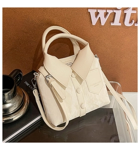 Detail of cream white shirt-shaped bucket bag with fold-over collar and button accents