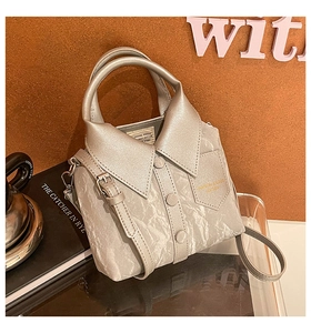 Close-up of a silver shirt-shaped bucket bag with realistic collar and button details