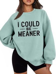 Detail of mint green oversized sweatshirt featuring black I COULD BE MEANER letter print