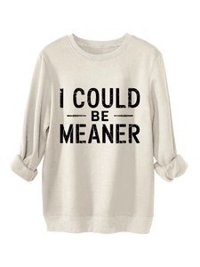 Close-up of 'I COULD BE MEANER' black artistic slogan on a thick beige sweatshirt fabric