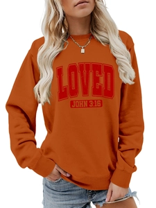 Detail view of orange crewneck sweatshirt featuring red LOVED print and ribbed cuffs