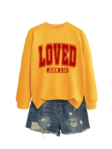 Detail view of yellow crewneck sweatshirt with vintage LOVED print and denim shorts