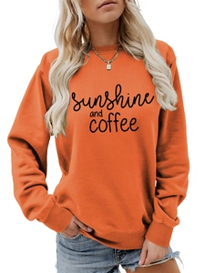 Detail of vibrant orange sweatshirt featuring sunshine and coffee print and ribbed cuffs