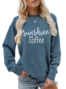 Close-up of sunshine and coffee letter print on blue crewneck sweatshirt fabric