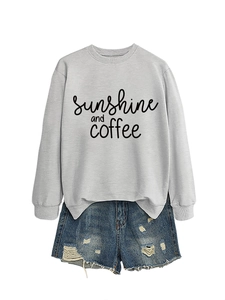 Detail of sunshine and coffee print on grey sweatshirt paired with ripped denim shorts