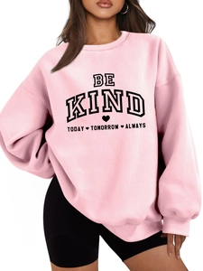Détail d'un sweat rose épais avec slogan Be Kind Today imprimé en noir sur le buste