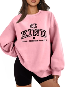 Détail du sweat rose à col rond avec texte BE KIND et poignets côtelés en coton