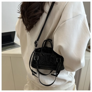 Detail of a black crocodile pattern mini tote bag with a drawstring bucket design