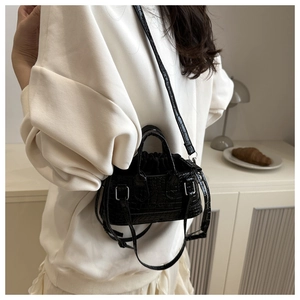 Detail of black crocodile texture bag with silver hardware and drawstring closure