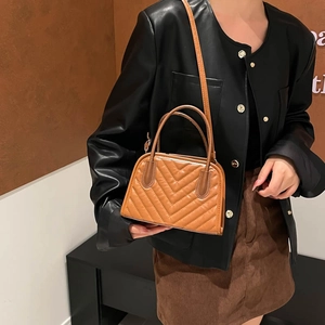 Brown chevron quilted crossbody bag with dual handles and adjustable shoulder strap