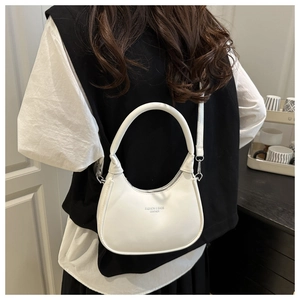 Detailed view of the white crescent bag showing fine stitching and fashion leather text