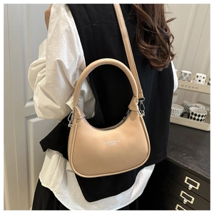Model view of beige crescent bag with adjustable strap and Fashion & Bags leather logo