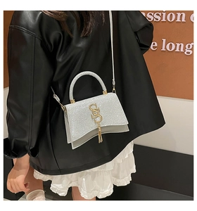 Borsa a tracolla con paillettes argento con logo SS in metallo e nappa su una modella
