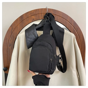Détail d'un sac de poitrine noir en nylon avec double fermeture éclair et bandoulière