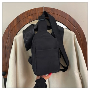 Détail d'un sac bandoulière en nylon noir avec fermeture éclair et sangle réglable