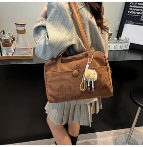 Brown suede tote bag with front snap pocket and cute plush monster pendant detail