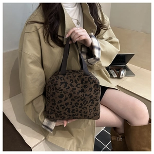 Corduroy leopard print tote bag styled with a beige trench coat in a cozy lifestyle setting