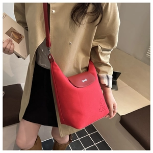 Dettaglio della borsa hobo in tela rossa con chiusura a forma di osso e motivo goffrato