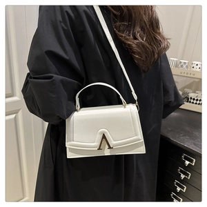 Gros plan détaillé d'un sac en cuir blanc avec une boucle en métal doré en forme de V