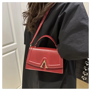 Sac à main rouge en cuir avec fermoir en métal doré en V et bandoulière amovible