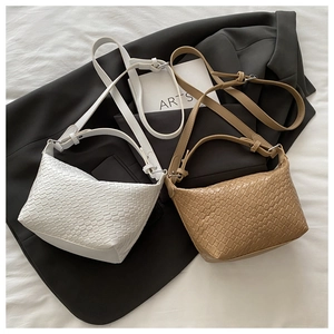 Flat lay of vintage woven texture crossbody bucket bags in white and tan colors