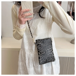 Detail shot of leopard print mini crossbody bag with gold metal and leather chain strap