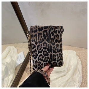 Close-up of leopard print mini crossbody bag featuring a stylish gold chain strap