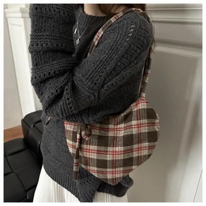 Détail du sac cabas à carreaux en laine porté avec un pull en maille gris chiné