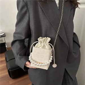 Fashionable cream leopard bucket bag with pearl handle and gold chain strap