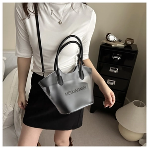 Sac seau en PVC gris translucide avec lanières en cuir noir dans un décor lifestyle