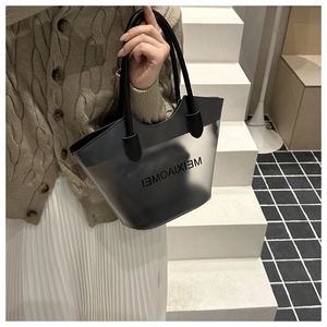 Détail d'un cabas en PVC gris semi-transparent avec poignées noires porté par un mannequin