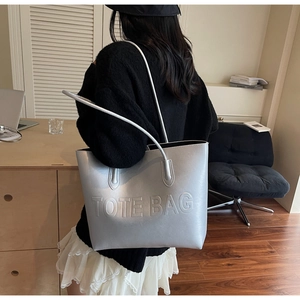 Detailed view of silver matte tote bag with embossed logo on a minimalist background