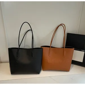 Detail view of large leather tote bags in black and brown with embossed texture