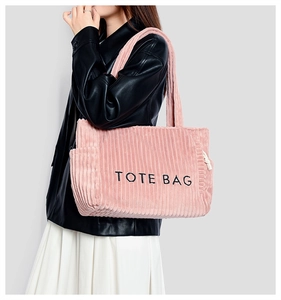 Détail du sac cabas en velours côtelé rose avec broderie TOTE BAG et poche latérale à cordon