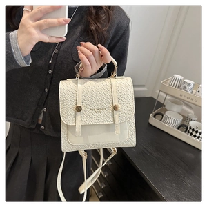 Close-up of white embossed leather backpack with gold hardware and TIDAL DRYNESS text