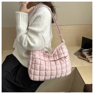 Gros plan du sac cabas matelassé rose avec bandoulière réglable porté par un mannequin