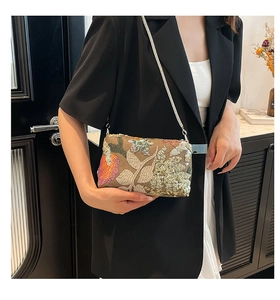 Detail of khaki sequin shoulder bag with floral embroidery and thin metal chain strap