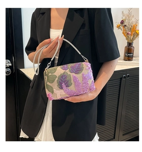 Detail of handmade purple and green sequin embroidery on a stylish evening clutch bag