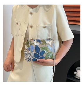 Close-up of sequin flower embroidery and silver chain on a stylish shoulder bag