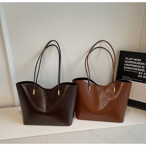 Close-up of minimalist glossy tote bags in coffee and reddish brown with gold hardware